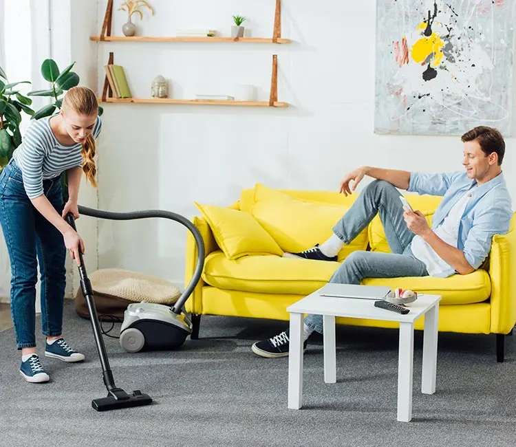 Professional house cleaning with vacuuming in a bright living room
