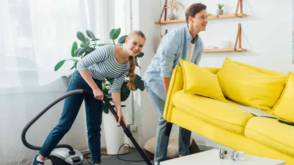 Team cleaning a living room together with care